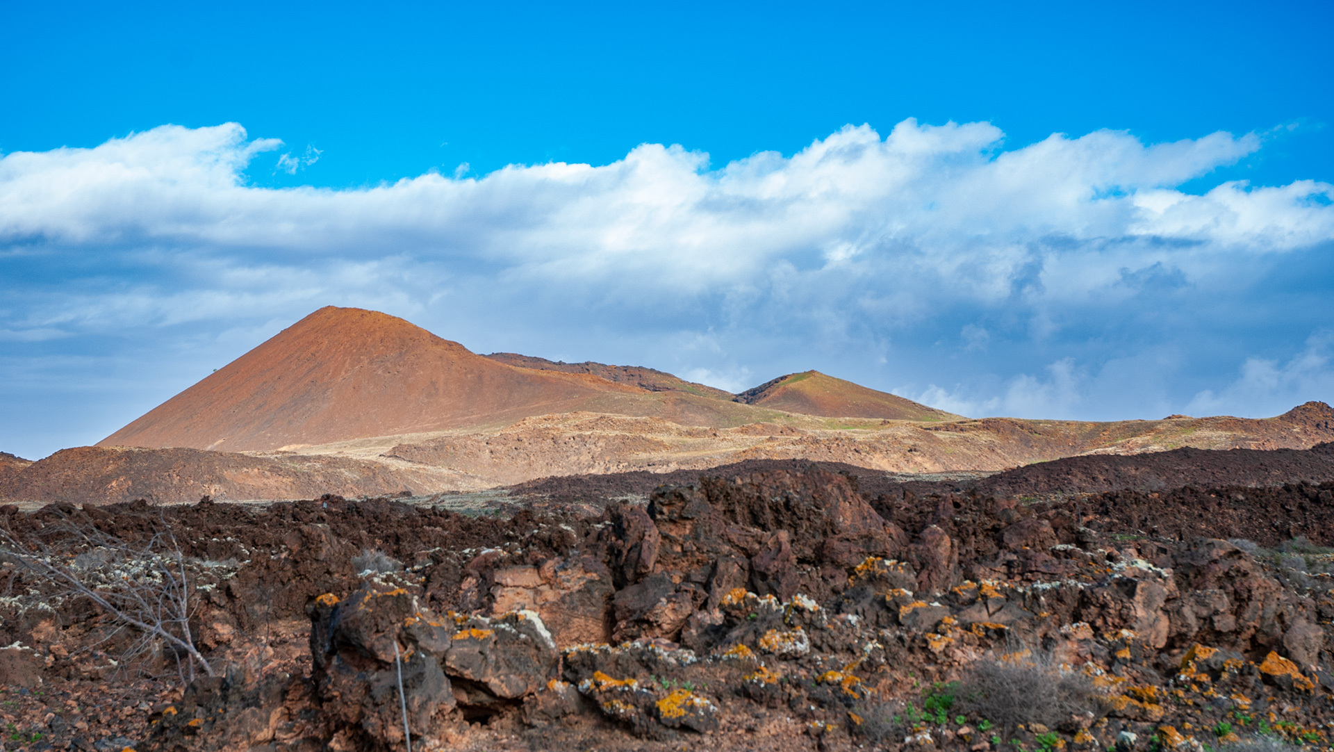 Vulkankrater hinter den Lavaverwerfungen des Malpaís